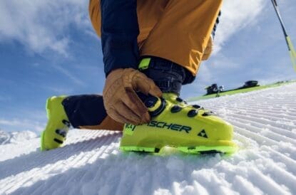BOA's new fit system - A man adjusts the dial on a yellow ski boot. Credit Tom Klocker Photo