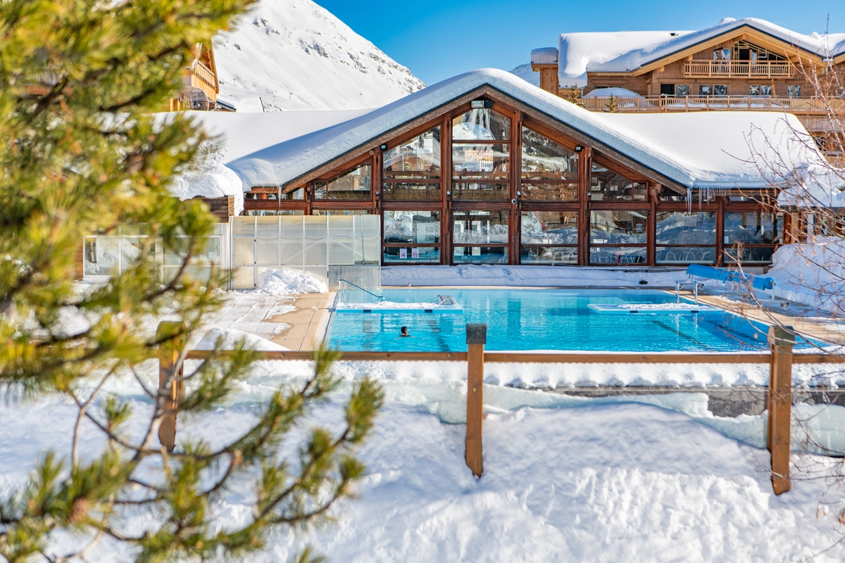an outdoor swimming pool surrounded by snow