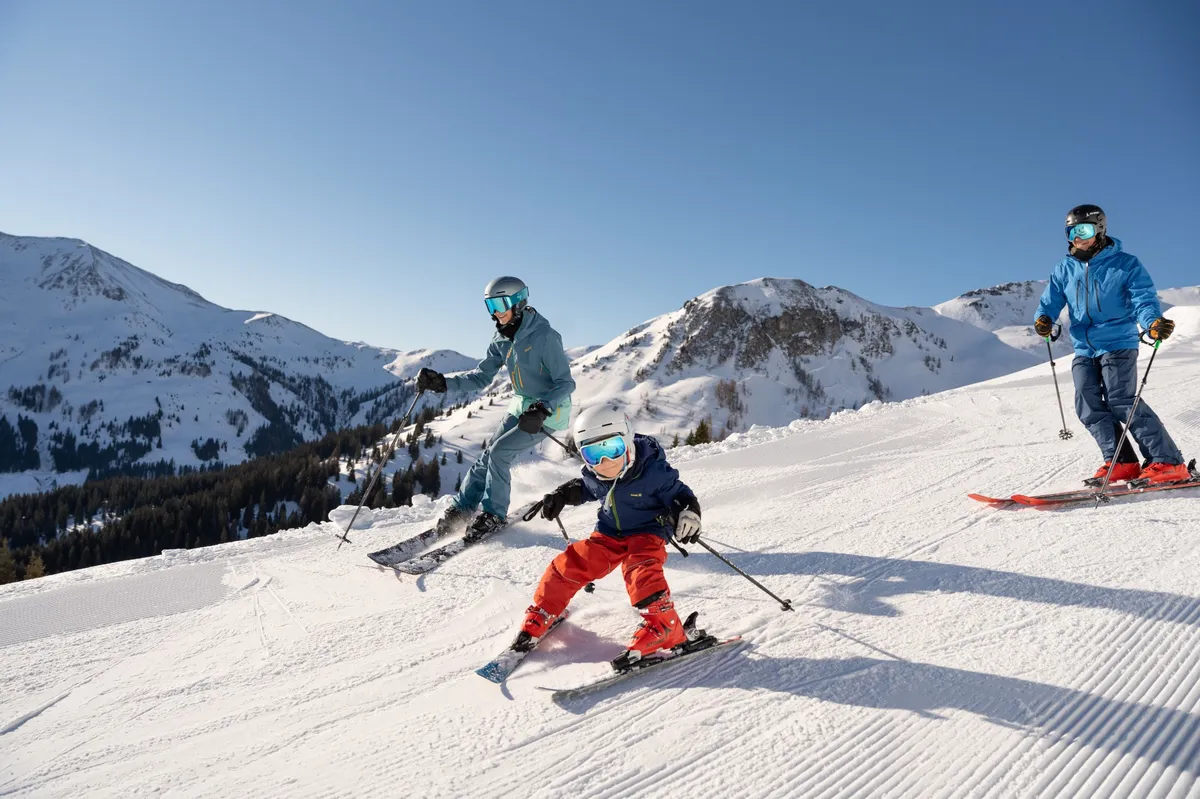 Parents skiing with child in the Skicircus Saalbach Hinterglemm