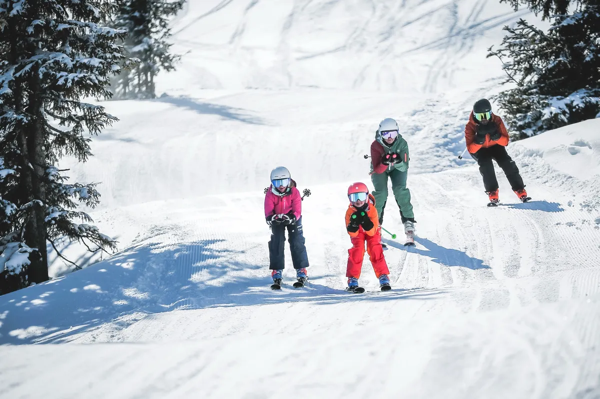 Family skiing together down a groomed piste in Saalbach Hinterglemm