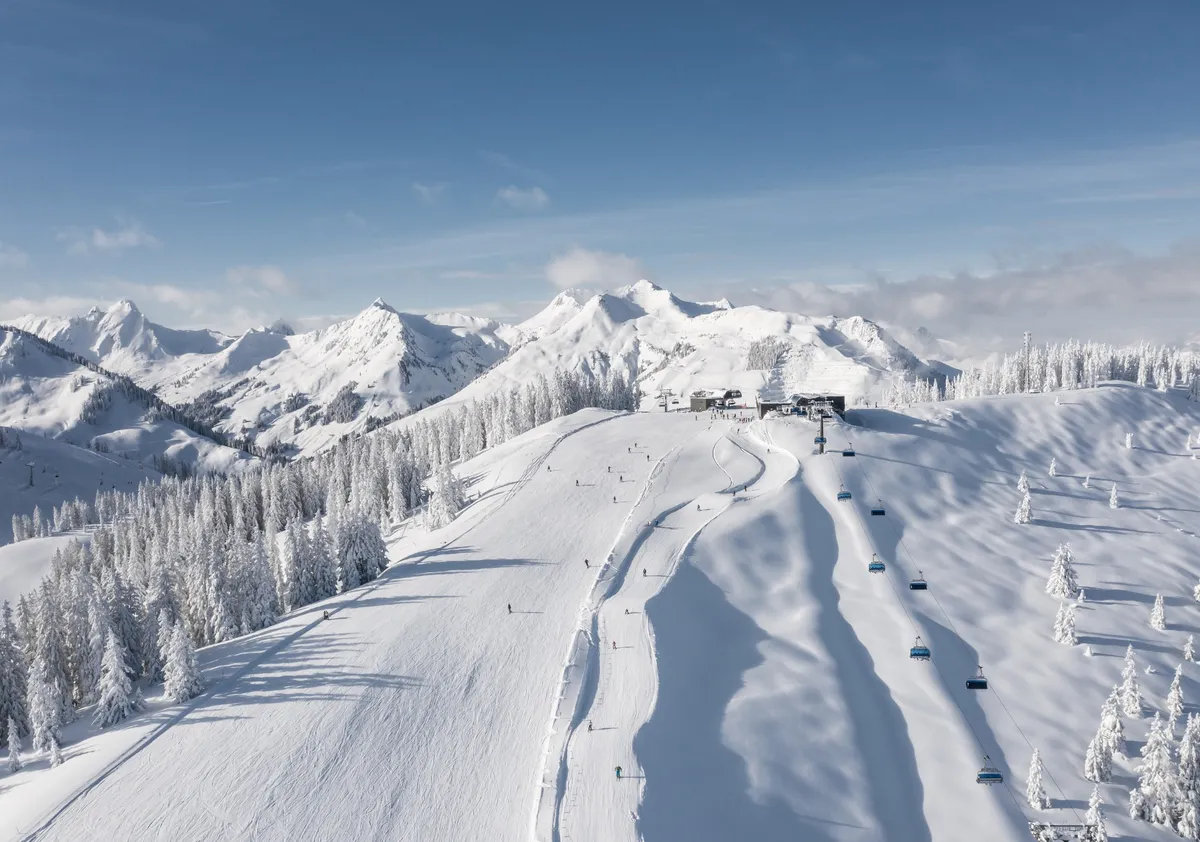 Aerial view of snowy pistes, lifts, and mountains in Saalbach Hinterglemm