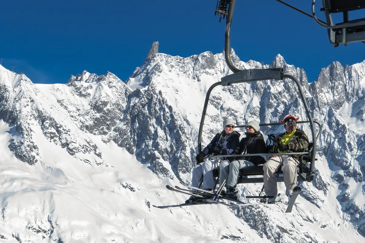Chairlift ride above Courmayeur with a dramatic view of the jagged Dente del Gigante peak etc in the Mont Blanc range, Aosta Valley
