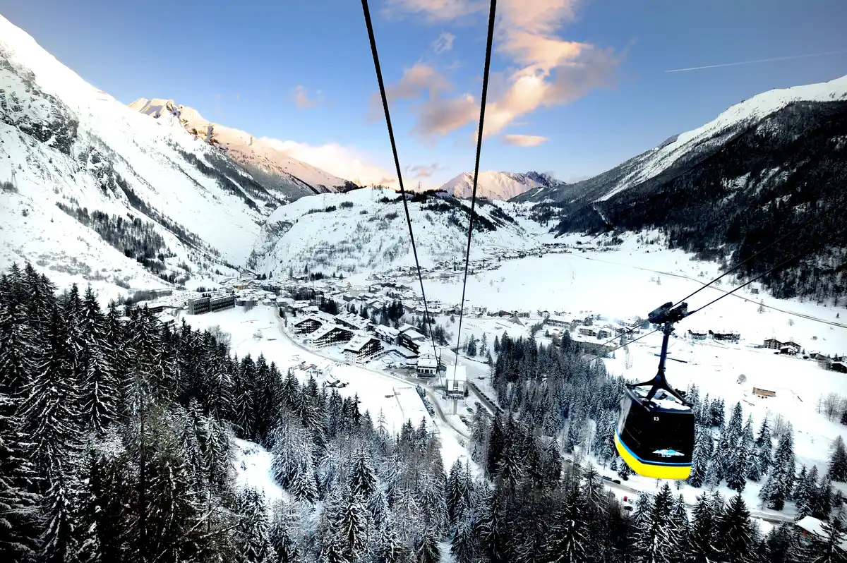 yellow-bottomed g ondola lift above snowy slopes at La Thuile in Aosta Valley.