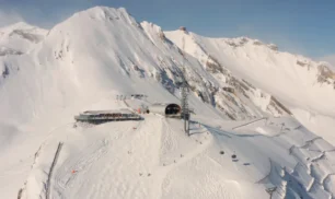 Aerial view of snowy mountain summit and ski lift infrastructure above Anzère