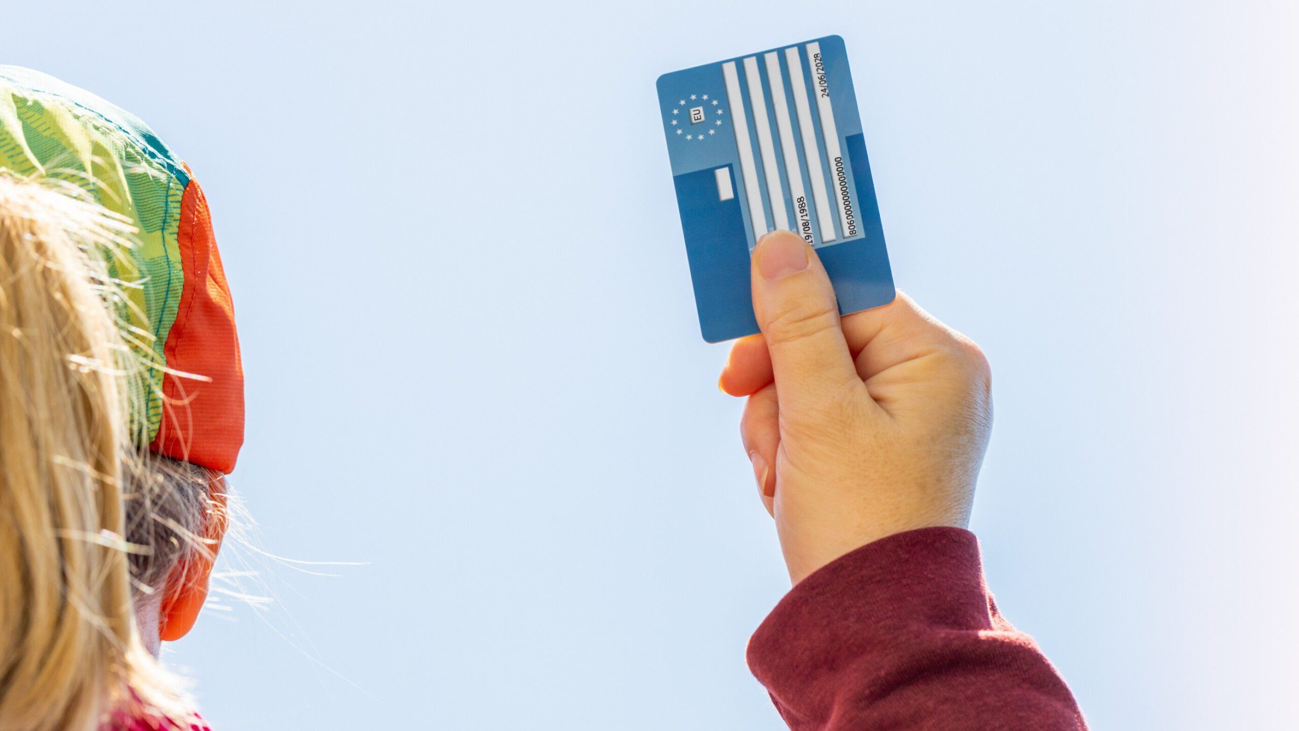 Woman holding EHIC card