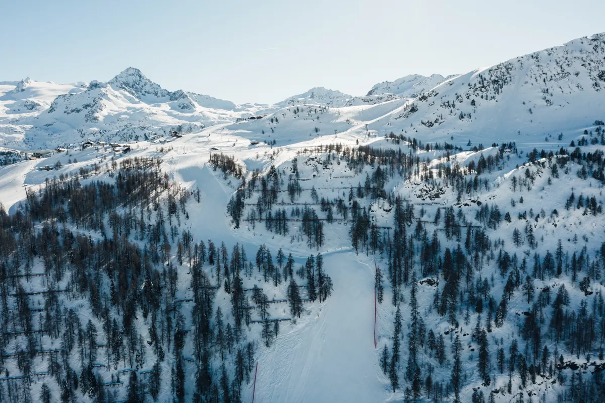 Snow-covered ski slopes and larch trees in La Thuile