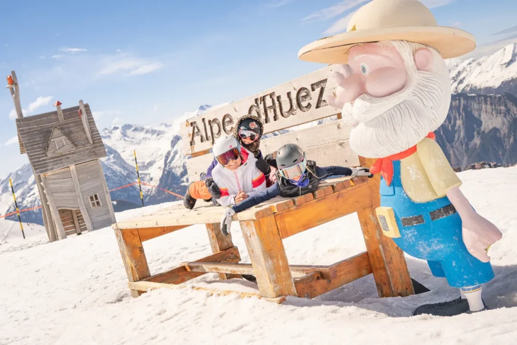 Family skiing at Alpe d’Huez with mountain scenery