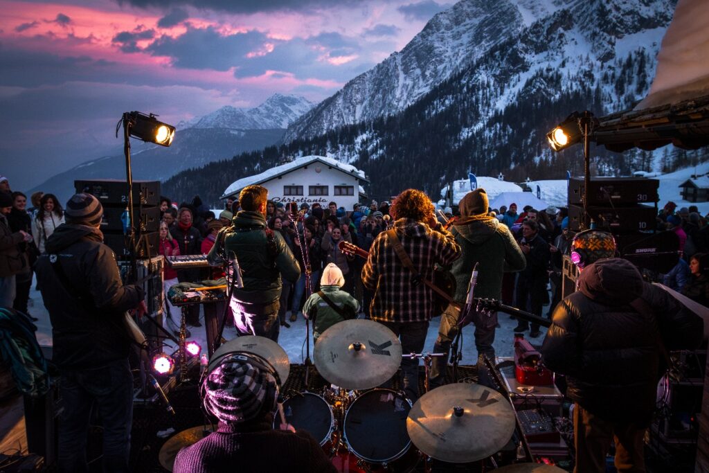 Live band playing to an après-ski crowd at dusk in the mountains above Courmayeur