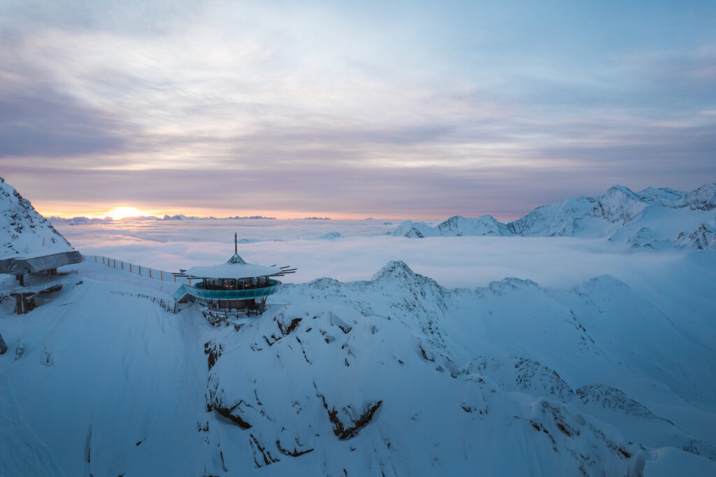 The Top Mountain Star panoramic bar on a snowy ridge above the clouds at dusk